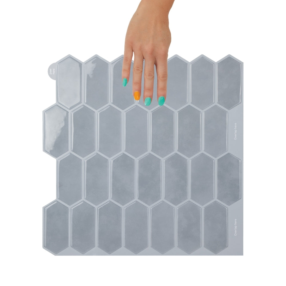 Hexagonal blue tiles held by a hand with multicolored nails on a white background