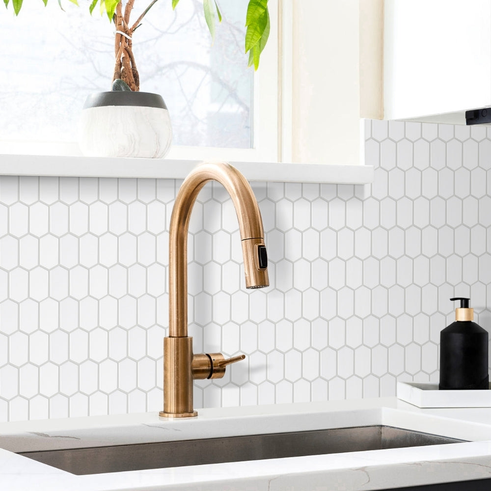 Bronze kitchen faucet in a modern kitchen setting with white tiled backsplash and plant.
