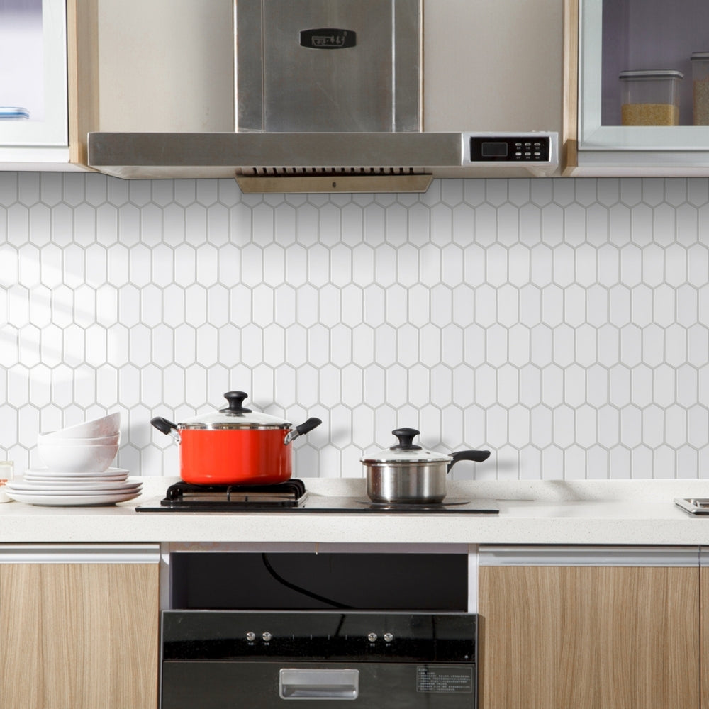 Modern kitchen with white hexagonal tiles on the wall, wooden cabinets, and a stove with pots.