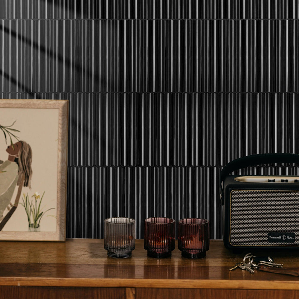 Decorative items on a wooden surface with a black textured wall in the background