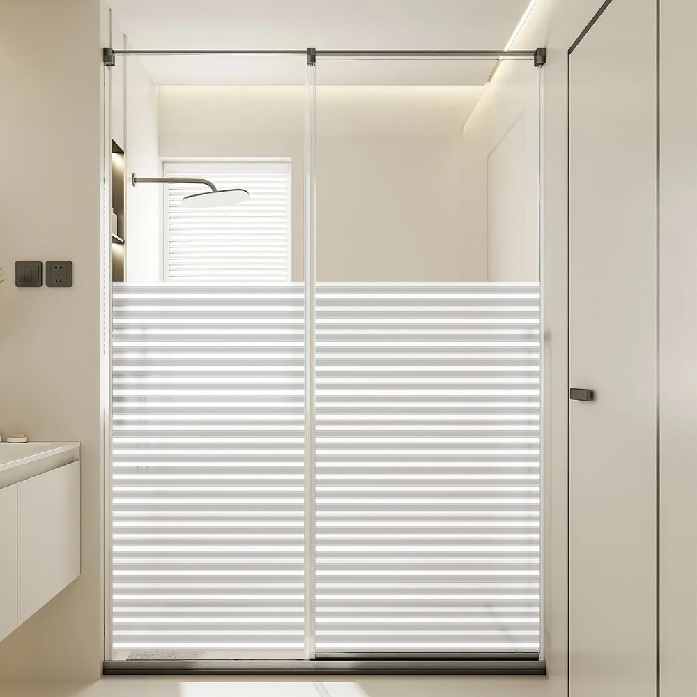 Bathroom with a reeded window film covered glass shower enclosure.