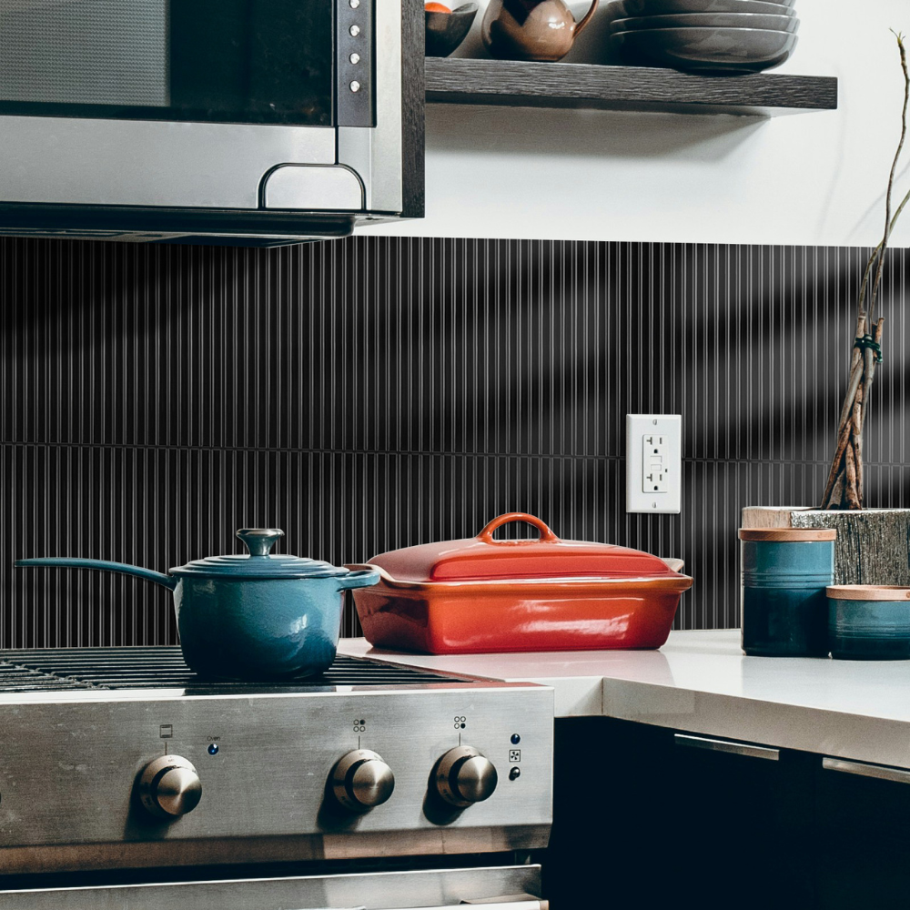Kitchen with a stove, pots, and a black tiled wall.