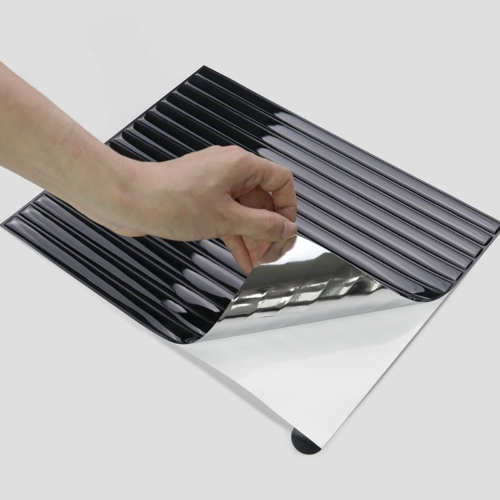 Person using peeling a black reeded tile