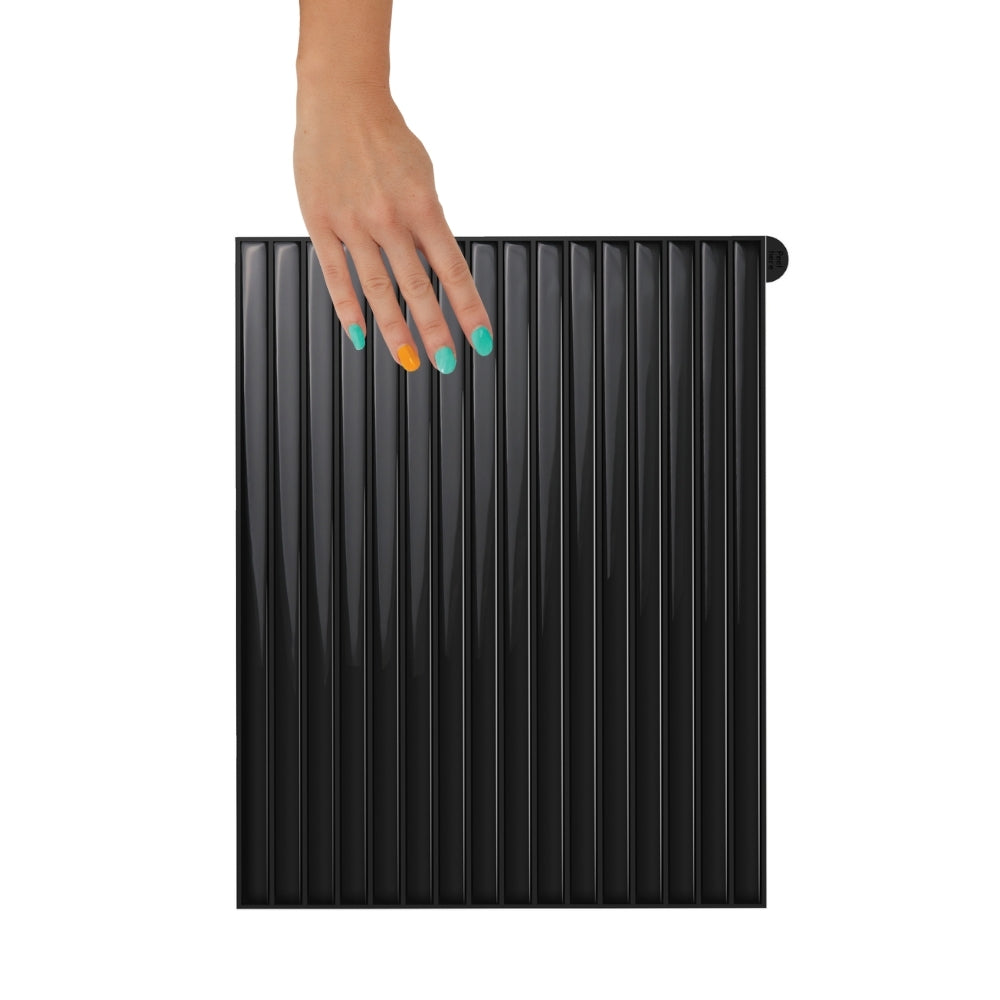 Black reeded tiles with a hand on a white background