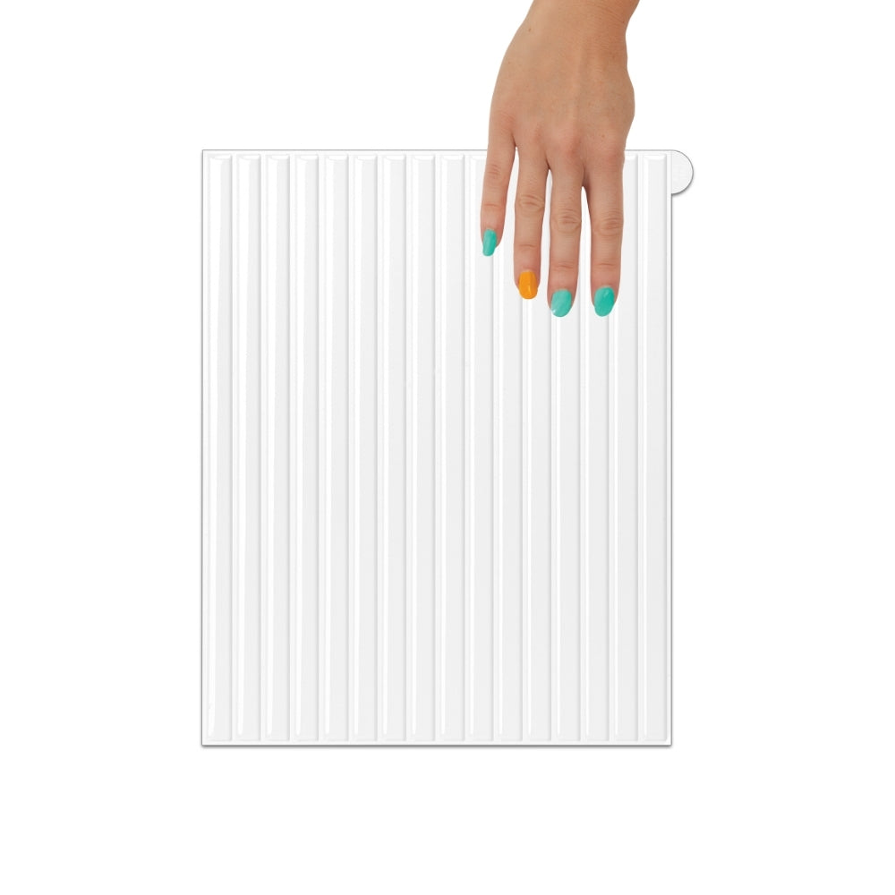 Hand holding a white reeded tile on a white background