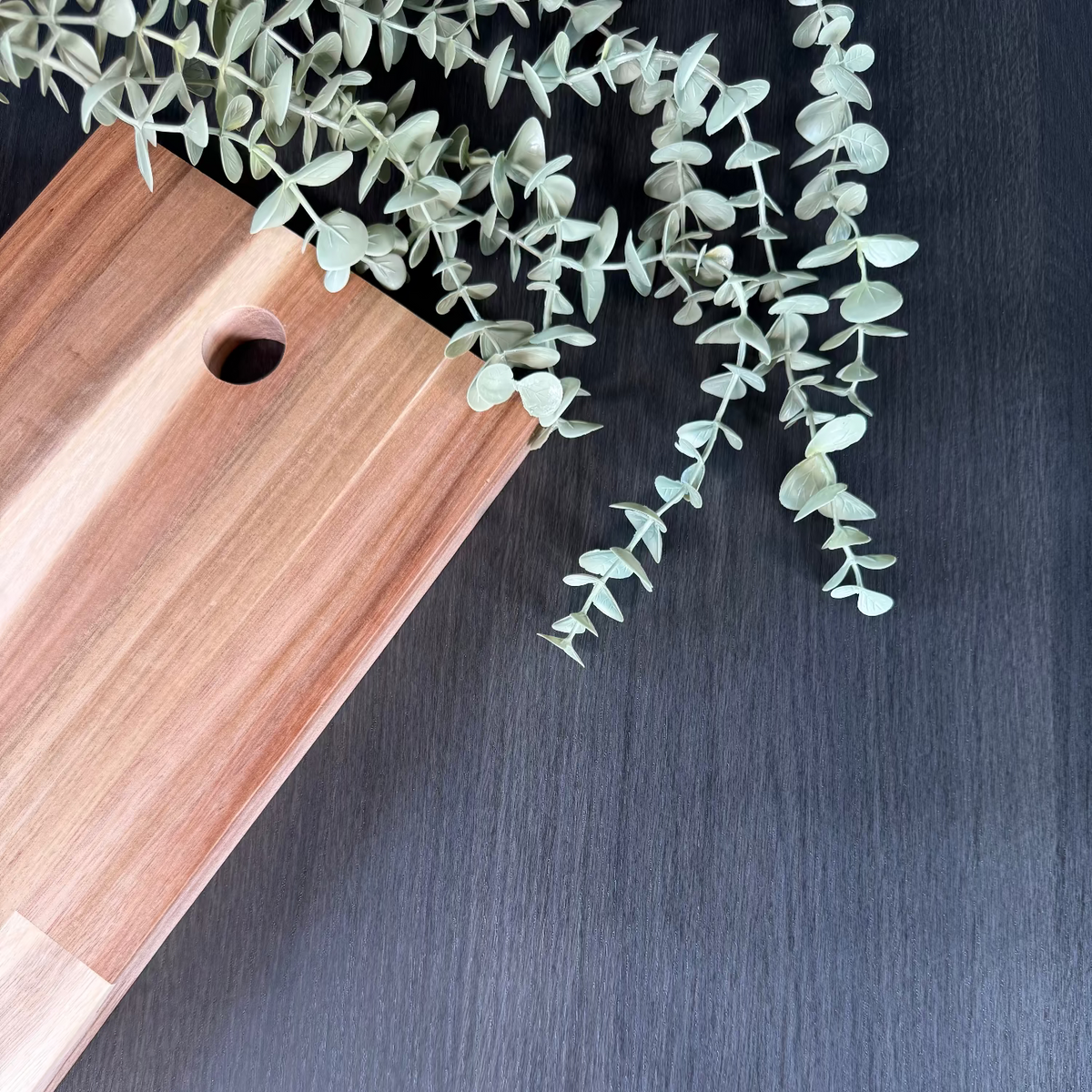 Wooden cutting board with a plant on black oak adhesive vinyl