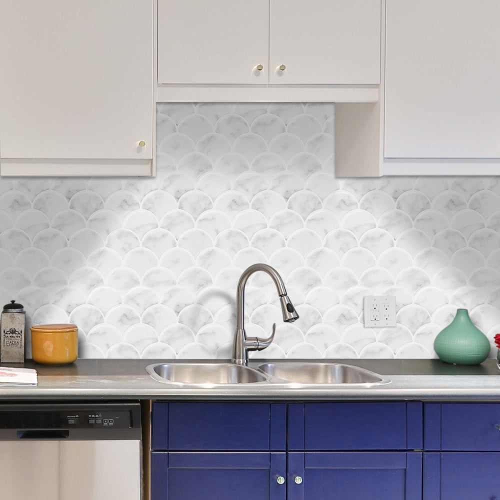 Modern kitchen with blue cabinets, stainless steel sink, and white patterned backsplash.