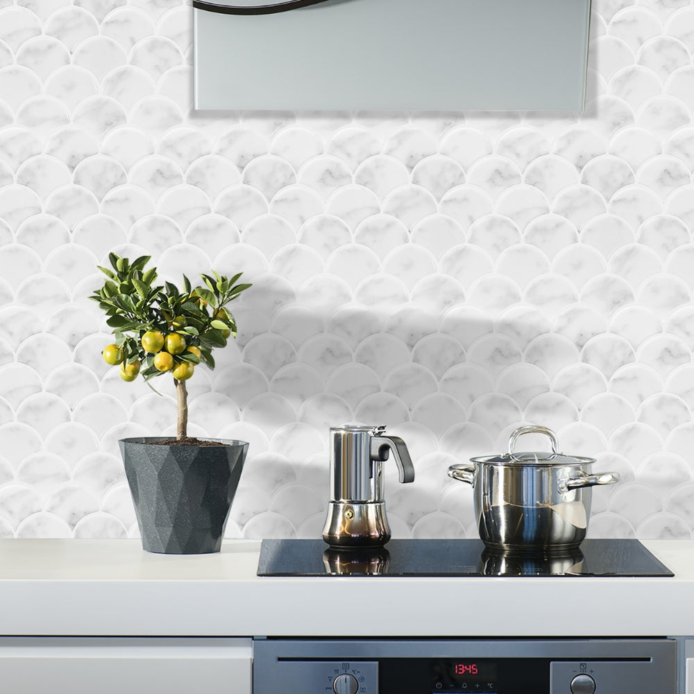 Kitchen counter with a potted plant, coffee maker, and pot against a textured white marble scalloped backsplash.
