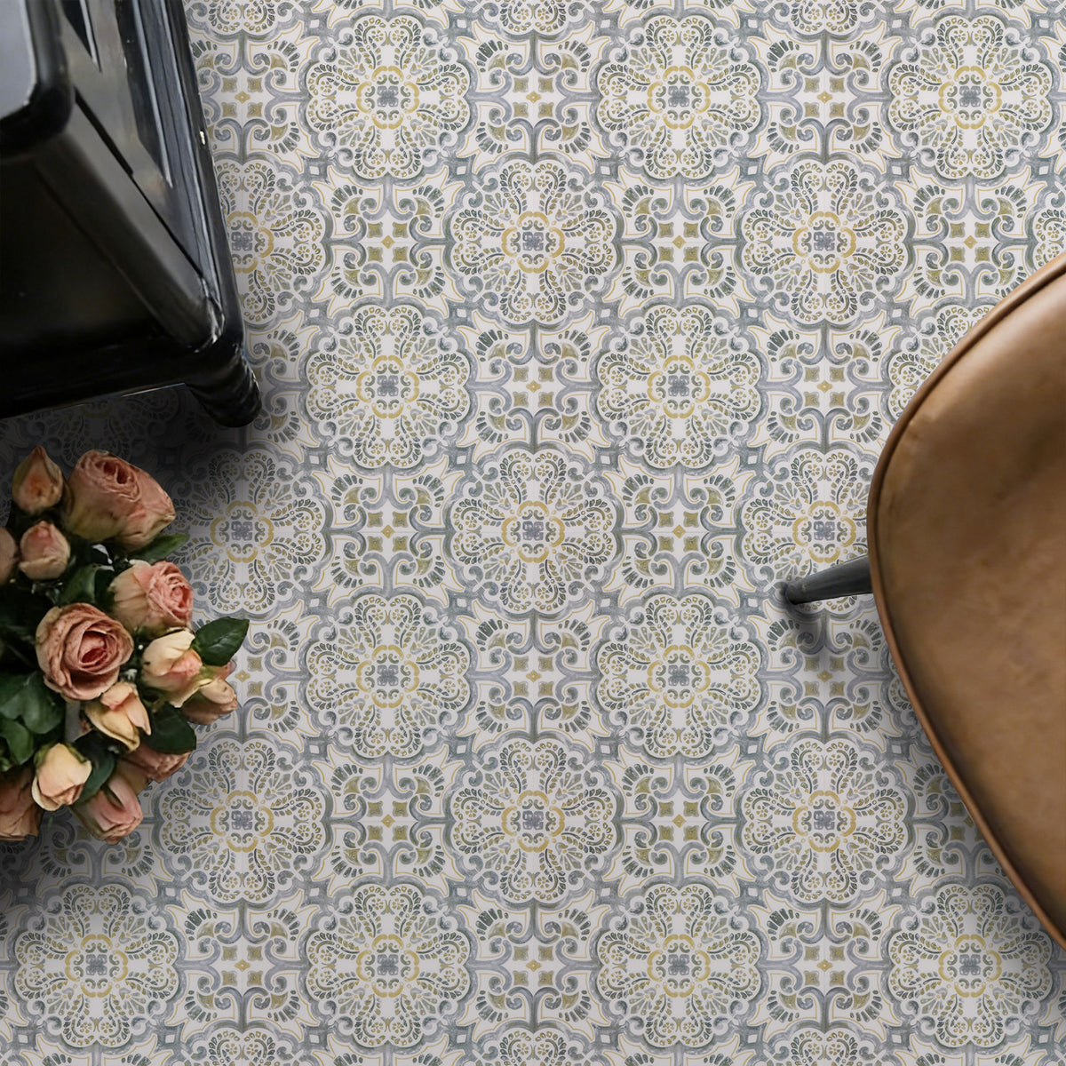 Patterned floor tiles with a vase of flowers and a chair on a patterned surface.