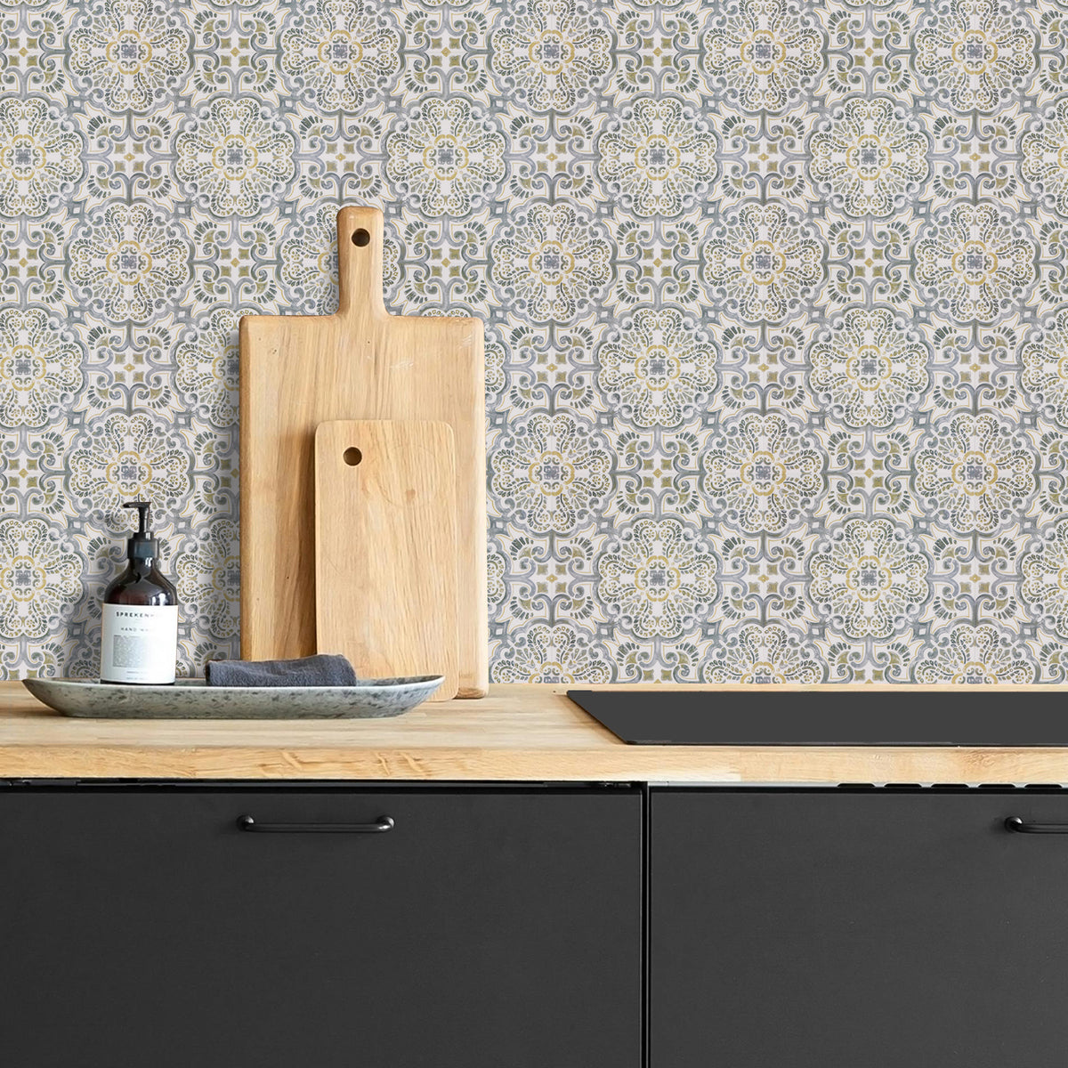 Kitchen counter with black cabinets, wooden cutting boards, and a patterned wall.