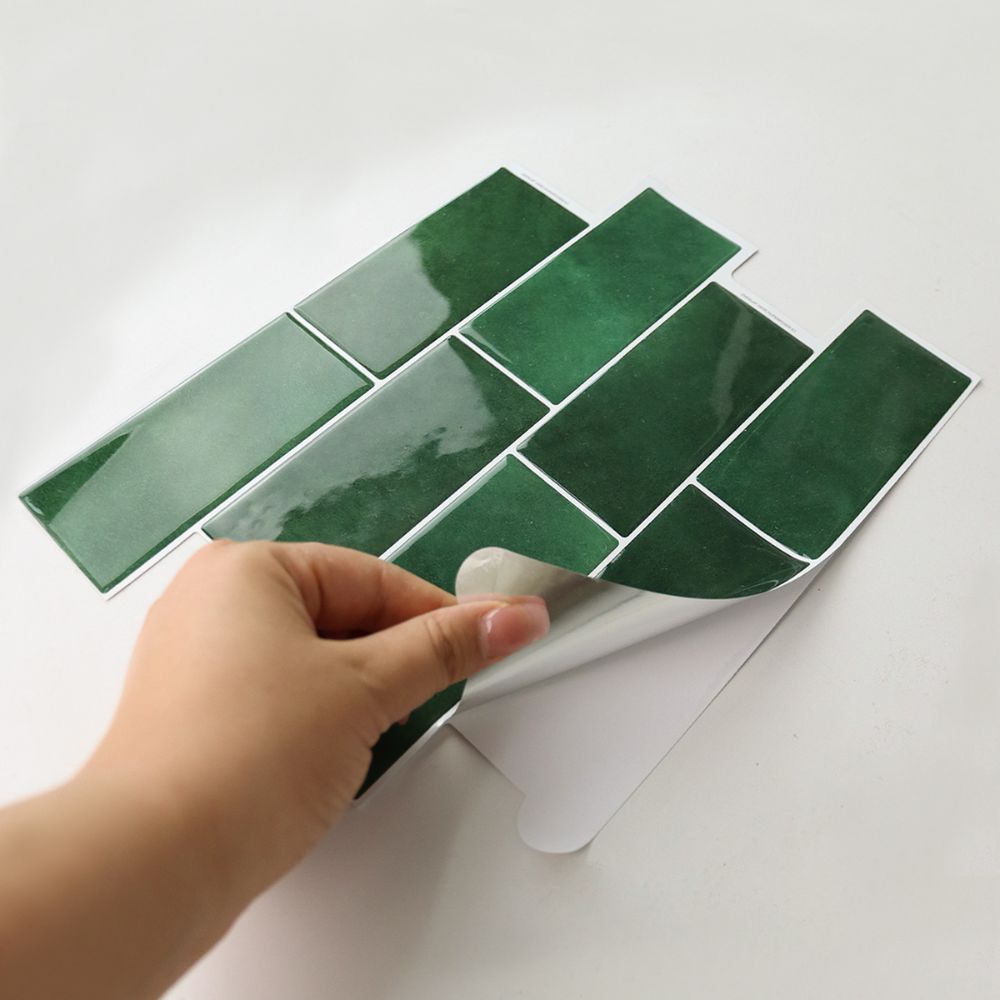 Hand peeling a peel and stick tile on a white background