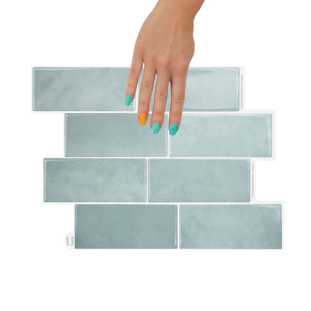 Set of peel and stick tiles with a hand holding one tile on a white background