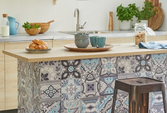 Kitchen island with grey, purple and min Moroccan tile wallpaper on front panel, metal barstool in front and breakfast on bench top