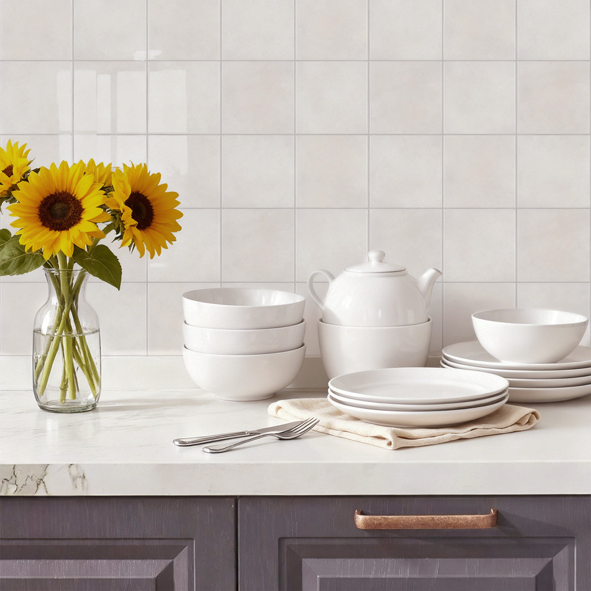 White ceramic tableware set on a kitchen counter with sunflowers in the background.