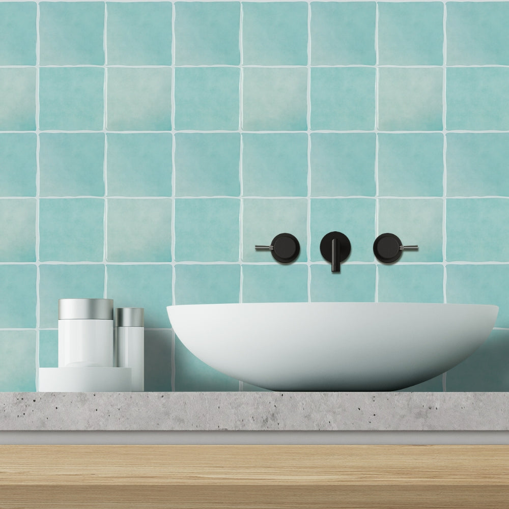 Bathroom sink with mint tiled wall and wooden vanity