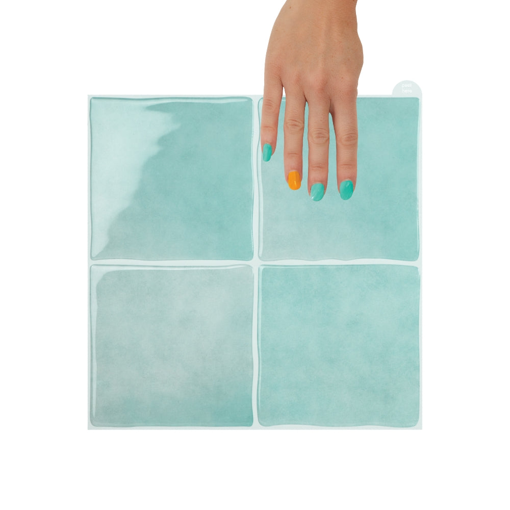 Hand holding a mint peel and stick tile on a white background