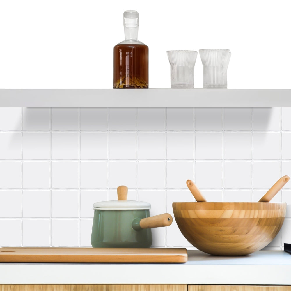 Kitchen counter with wooden bowl, green pot, and white tiles on the wall.
