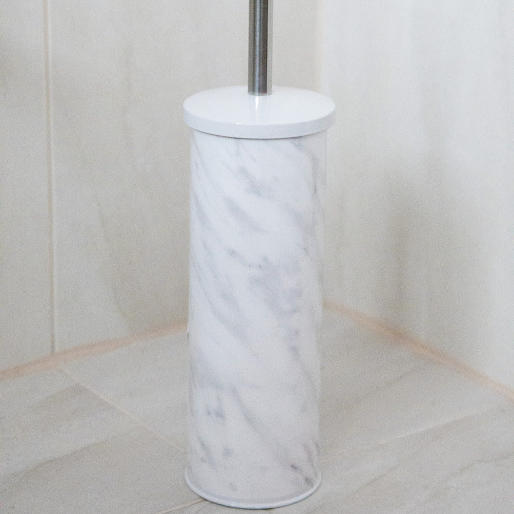 Marble-textured toilet brush holder with a silver handle against a tiled bathroom wall.