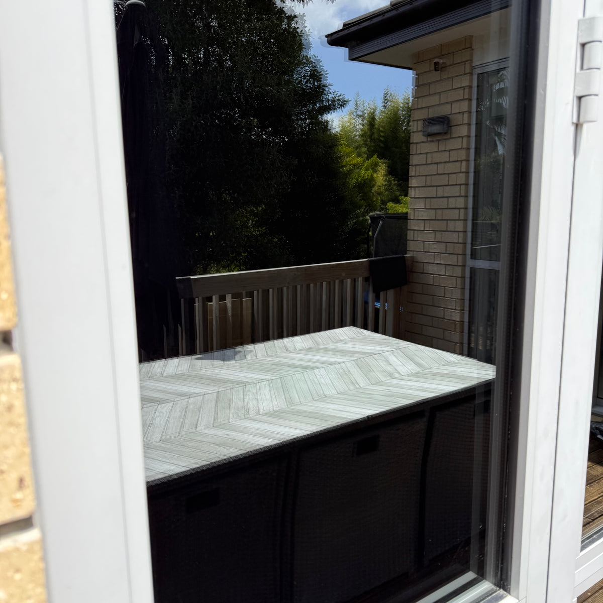 Outdoor setting with a table and chairs on a sunny day shown in a mirror reflective film