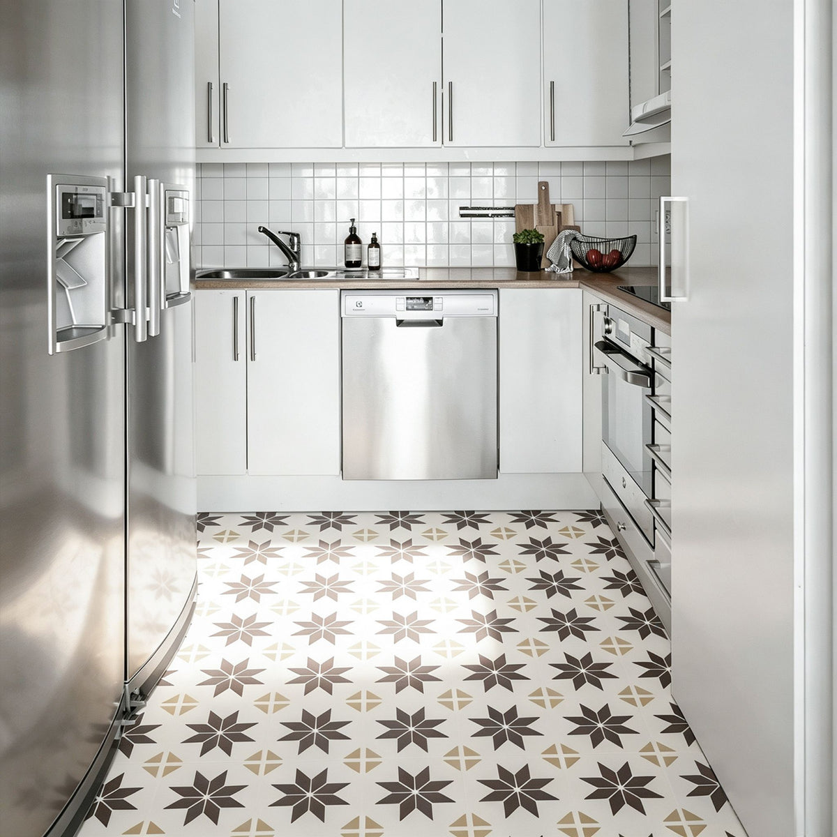 A modern kitchen interior with white cabinets, stainless steel appliances including a refrigerator and dishwasher, a tiled backsplash, and patterned floor tiles in white, beige, and brown.