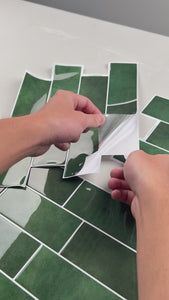 Installation of green peel and stick subway tiles