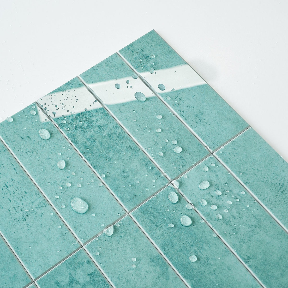 distressed teal stacked subway tiles with water droplets on them on a white background